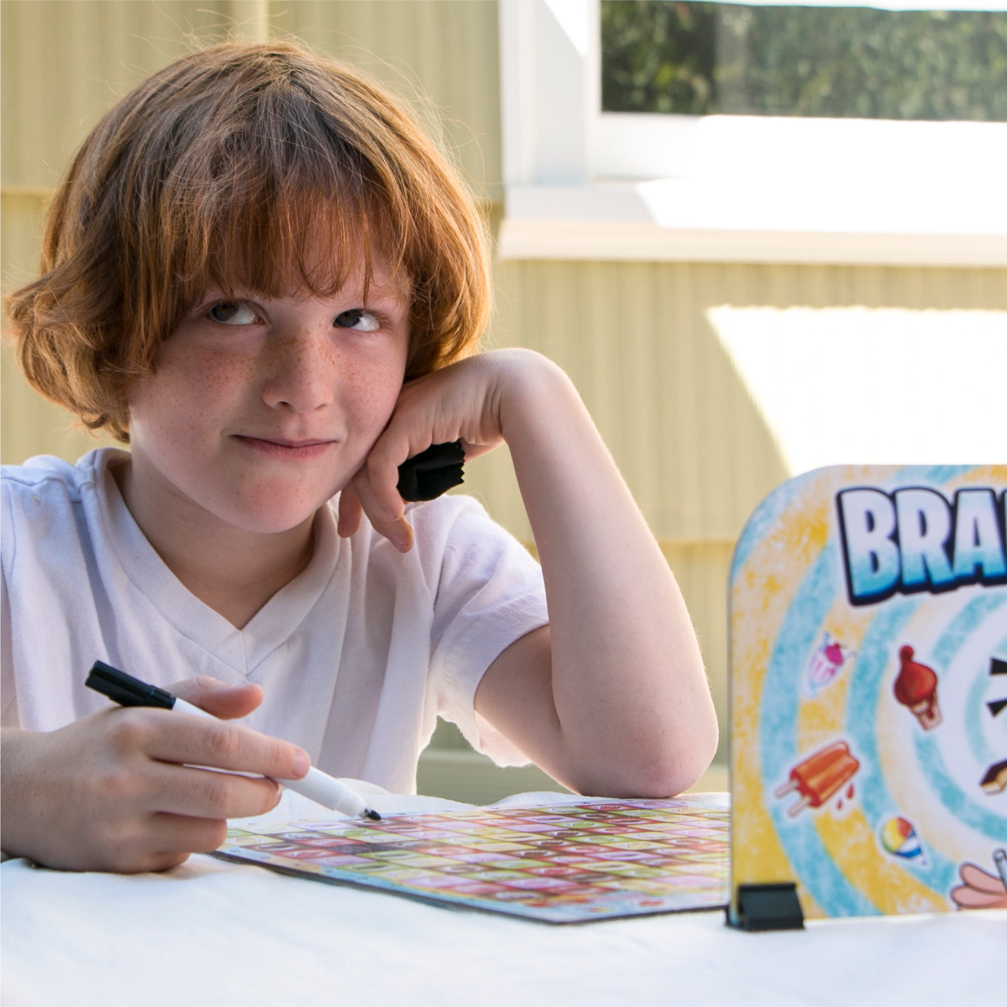Boy playing Brain Freeze strategy board game by Mighty Fun!