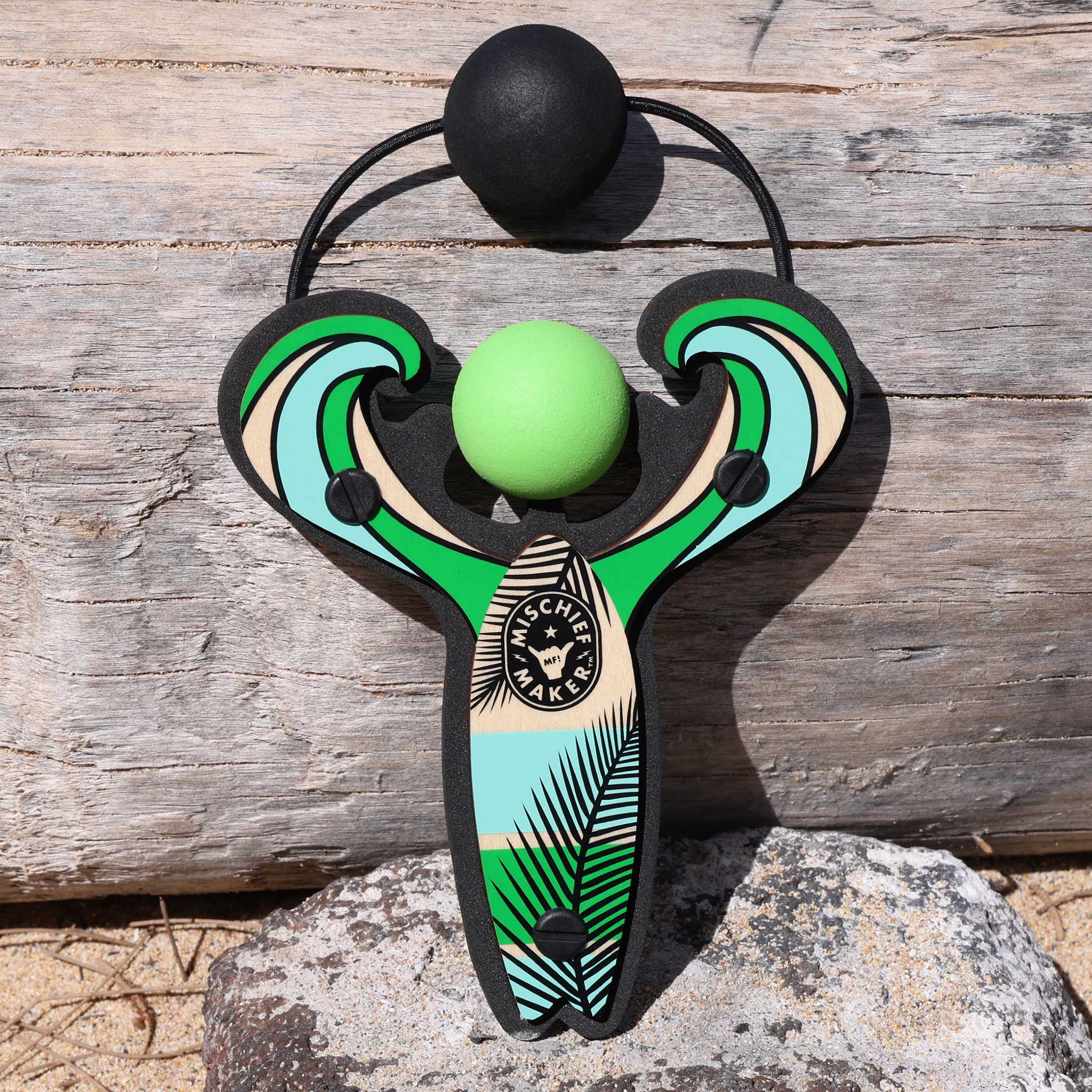 Green Surf’s Up toy slingshot with ball foam ball by the ocean. Mischief Maker by Mighty Fun!