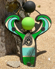 Green Surf’s Up toy slingshot in the sand on the beach. Mischief Maker by Mighty Fun!