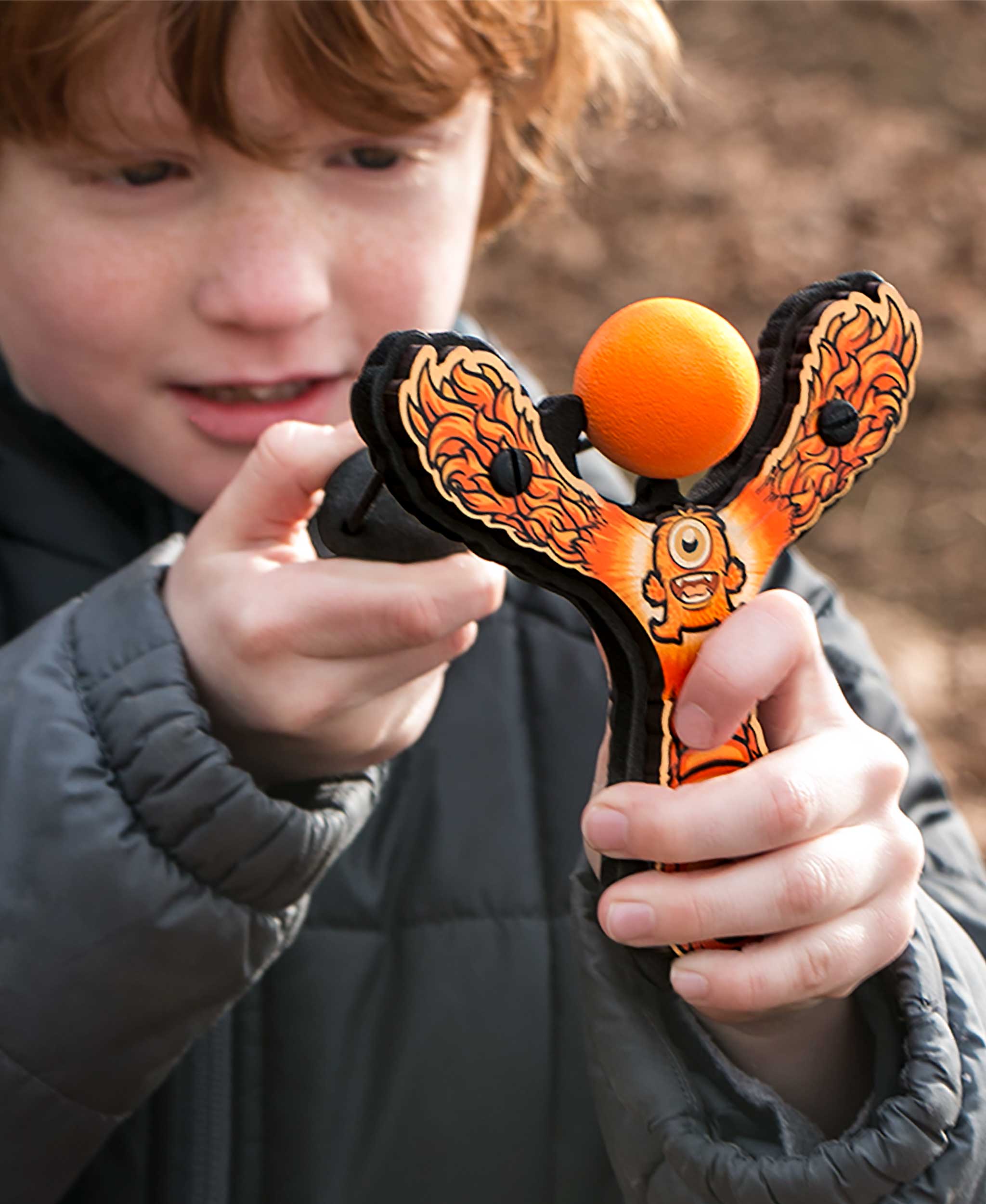 Kid shooting Mischief Maker Slingshot by Mighty Fun! outside
