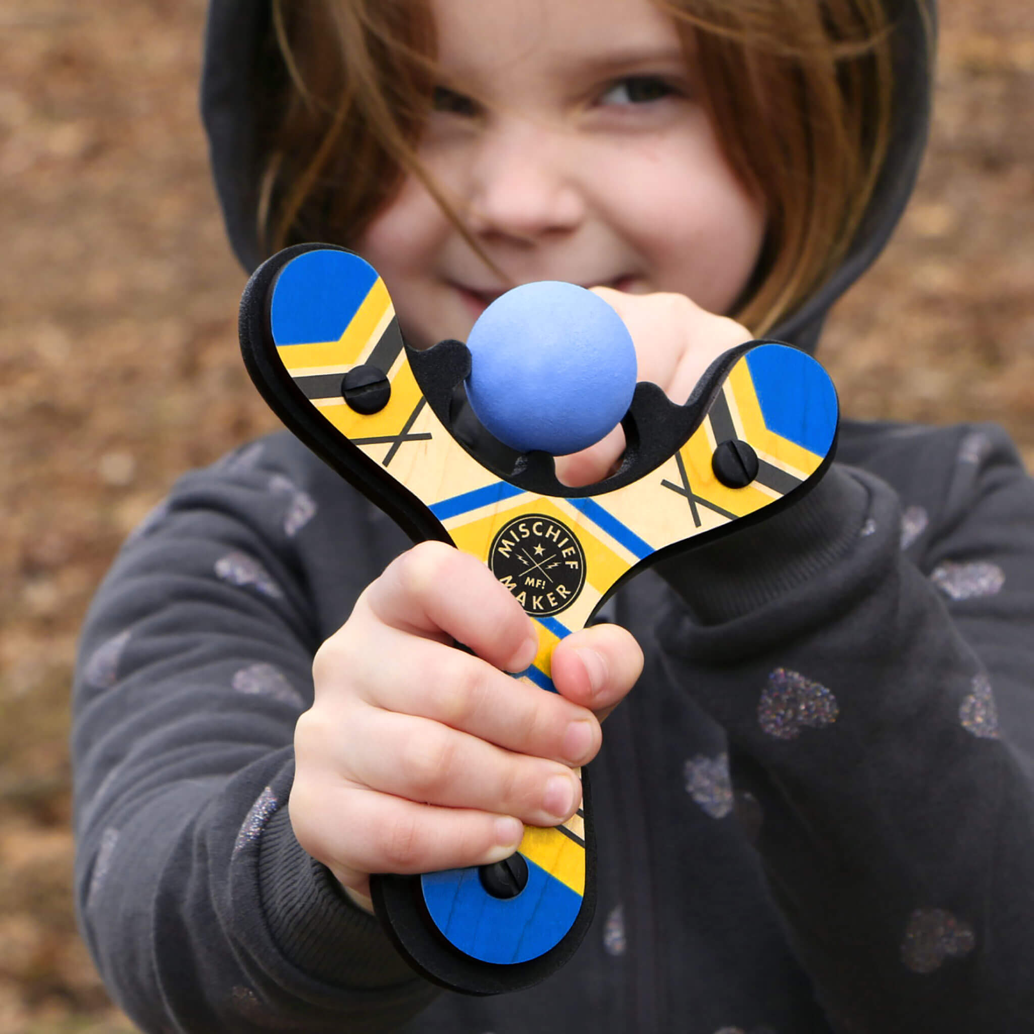 Blue Classic wood slingshot being launched by 6 year old girl outside by Mighty Fun!