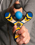 Blue classic wooden Mischief Maker kids toy slingshot being shot. By Mighty Fun!