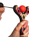 Red Classic wood slingshot being launched. Mischief Maker by Mighty Fun!