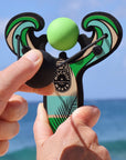 Green Surf’s Up toy slingshot being launched by the ocean. Mischief Maker by Mighty Fun! 