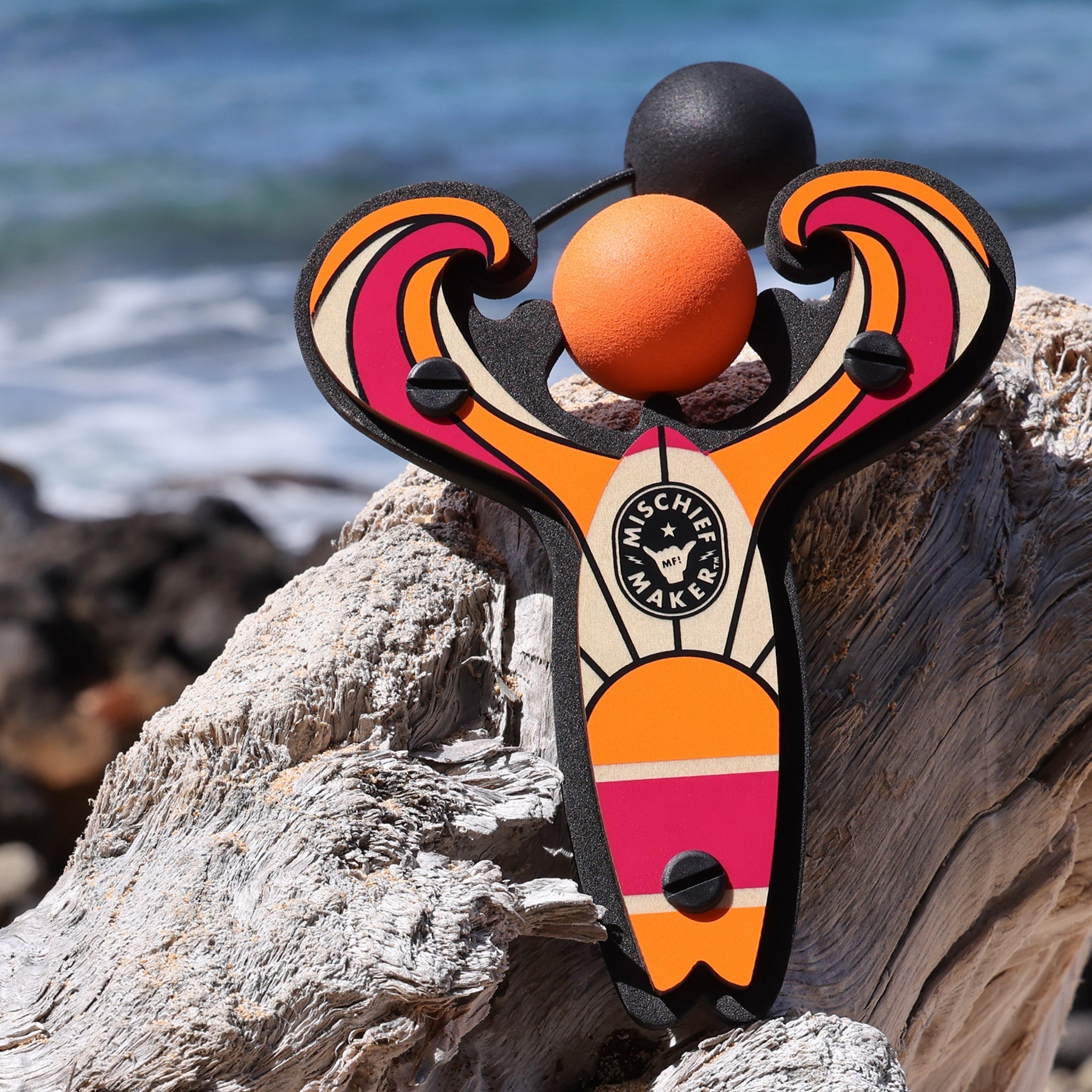 Orange Surf’s Up toy slingshot by the beach. Mischief Maker by Mighty Fun!