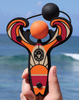 Orange Surf’s Up toy slingshot hand held with ball foam ball by the ocean. Mischief Maker by Mighty Fun!