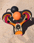 Orange Surf’s Up toy slingshot in the sand on the beach. Mischief Maker by Mighty Fun!