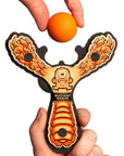 Orange Monster toy slingshot being loaded with a soft foam ball. Mischief Maker by Mighty Fun!